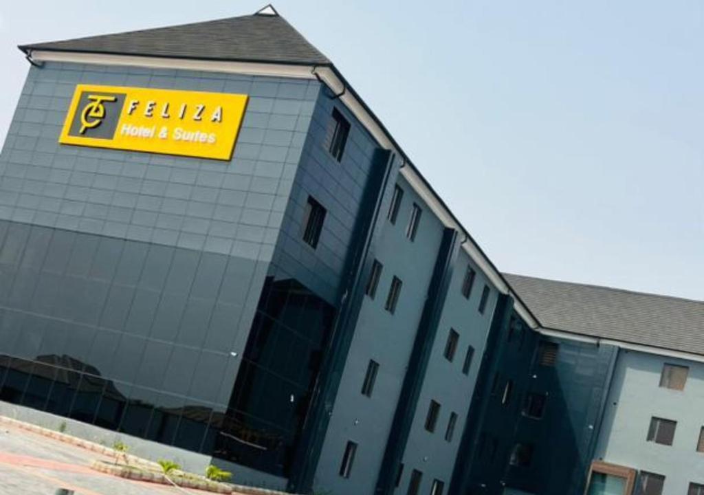 a building with a yellow sign on the side of it at Feliza Hotel and Suites in Abeokuta