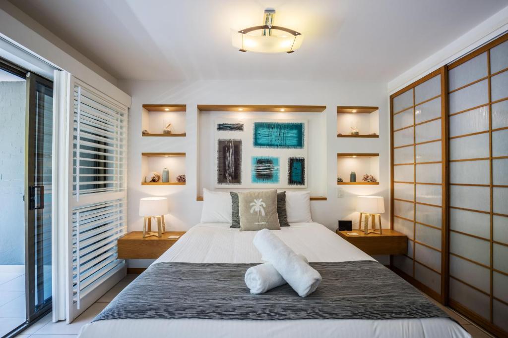 a bedroom with a large bed and a large window at Saks on Hastings in Noosa Heads