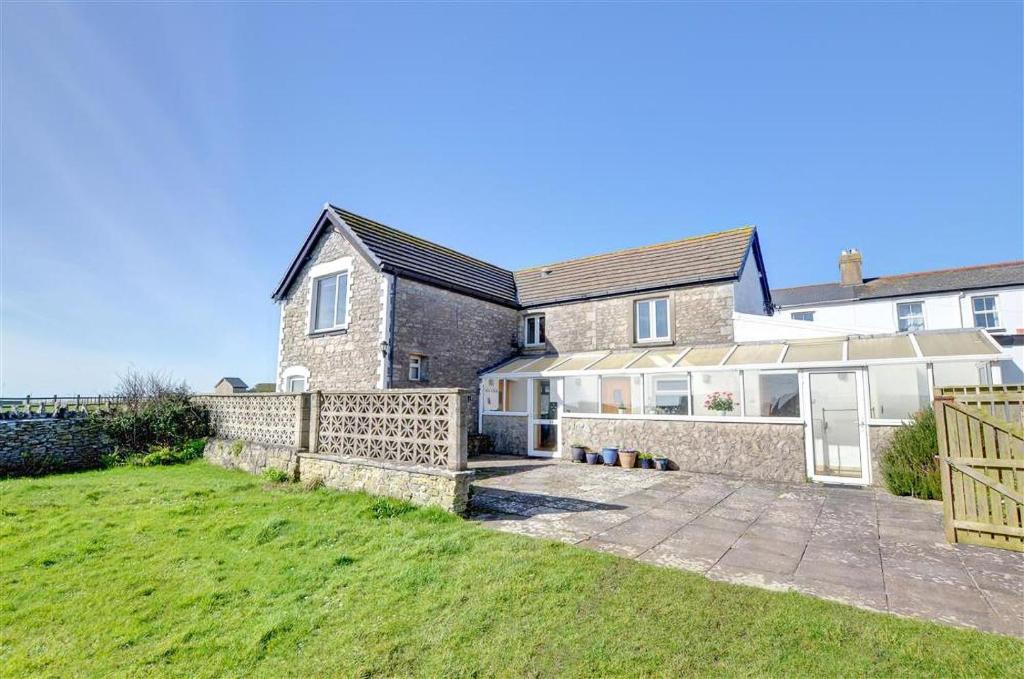 a house with a fence and a grass yard at 3 Bed in Southerndown oc-way216 in Southerndown