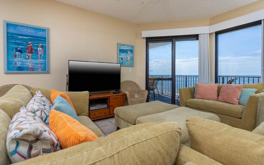 a living room with a couch and a flat screen tv at Phoenix VI 61204 in Orange Beach