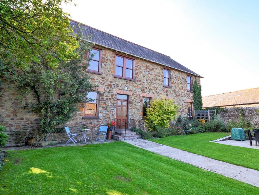 a brick house with a lawn in front of it at 4 Bed in Bude oc-ssham in Stratton