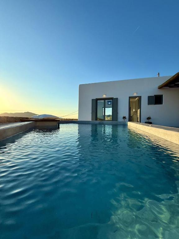 a swimming pool in front of a house at Sunwave Mykonos Villa in Mykonos