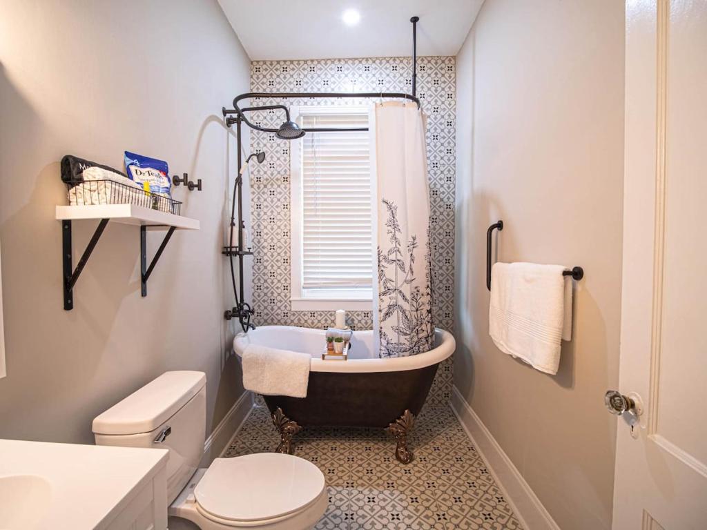 a bathroom with a tub and a toilet and a sink at Marietta Square's Home Away! in Marietta