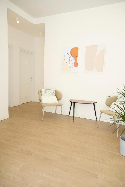 a room with chairs and a table and a painting at Room45 in Marzamemi
