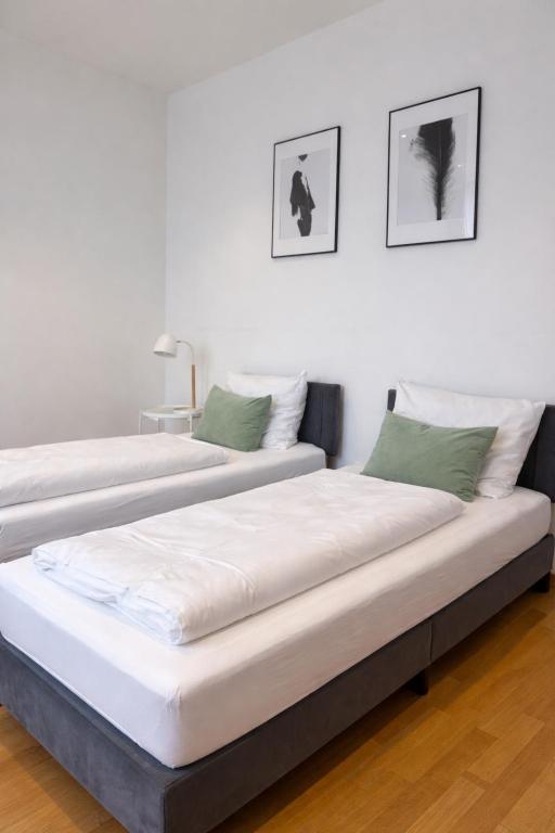 two beds sitting next to each other in a room at Kaza Guesthouse, centrally located 2 & 3 bedroom Apartments in Augsburg in Augsburg