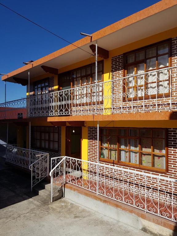 a yellow building with balconies on the side of it at Very cute and spacious complete house with a fireplace! in Teziutlán
