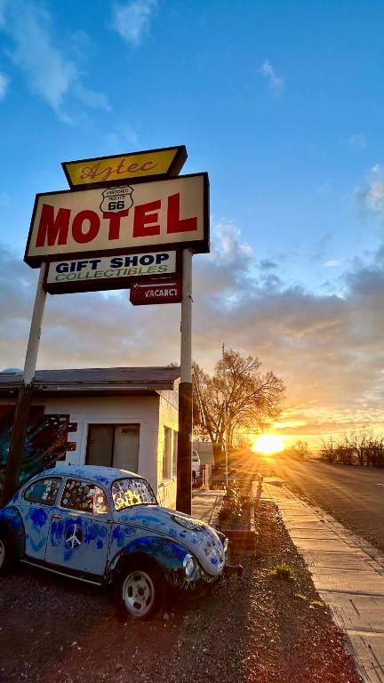 a car is parked in front of a motel sign at The Aztec Motel & Creative Space in Seligman