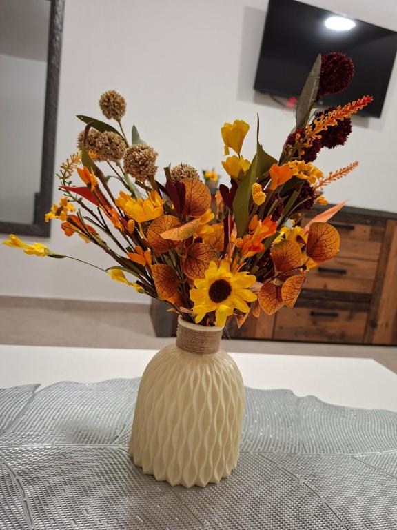 a vase with flowers in it on a table at Apartmani Preradović in Pančevo