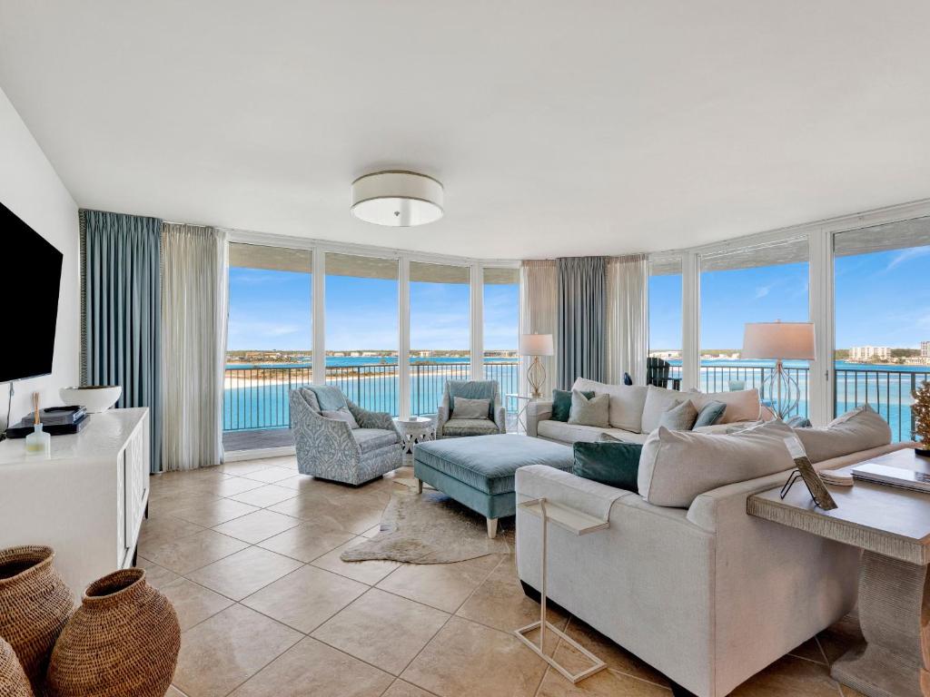 a living room with a couch and chairs and windows at Caribe The Resort #C702 in Perdido Key