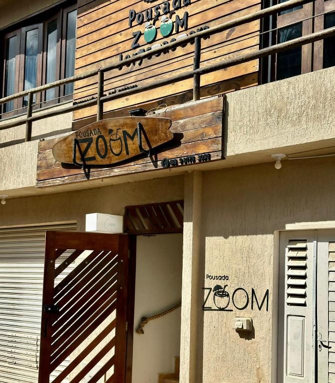 a sign on the side of a building with a door at Pousada Zoom Jericoacoara in Jericoacoara