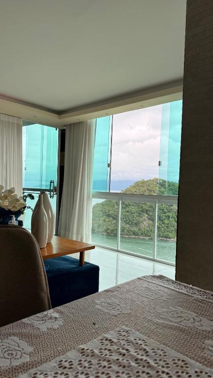 a room with a bed and a large window at Casa vista infinita in Mangaratiba