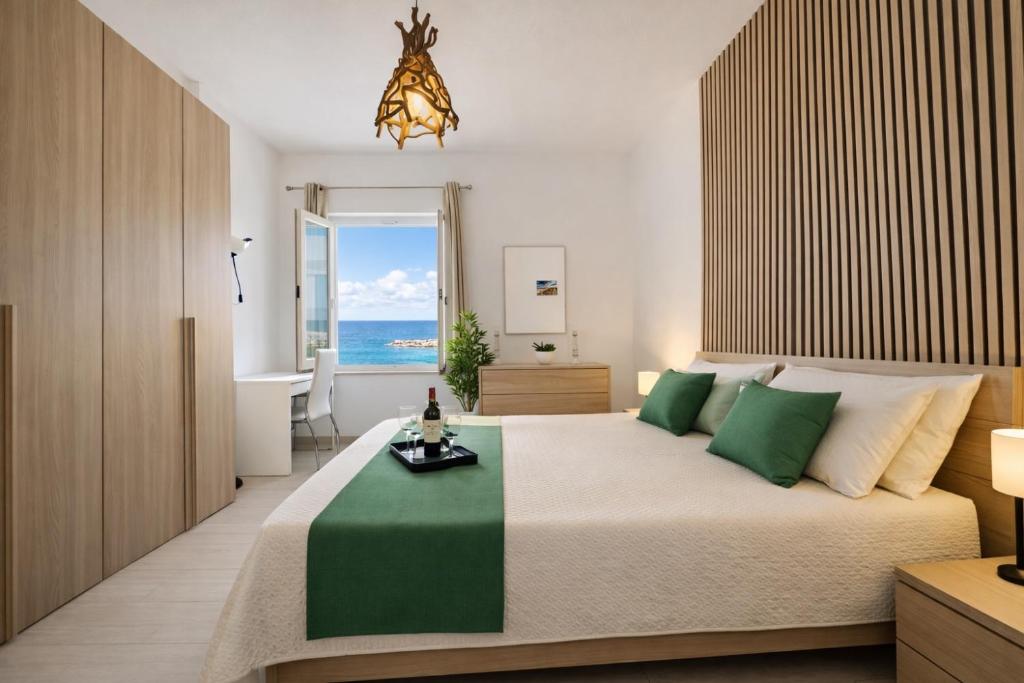 a bedroom with a large bed with a view of the ocean at Demetra Seafront Apartment - Parking & Pool in Castel Volturno