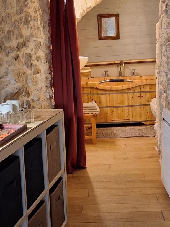 a bathroom with a wooden tub and a sink at La chambre secrète in Aiguèze