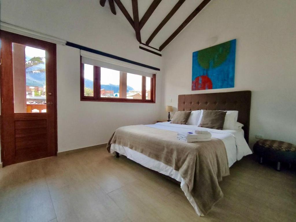 a bedroom with a large bed and a window at Casa ONCE ONCE in Villa de Leyva