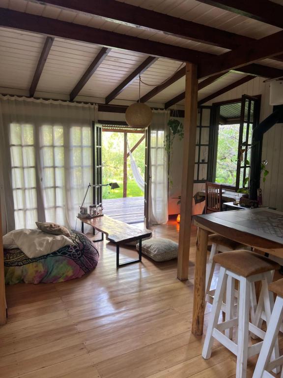 a living room with a table and a wooden floor at Cabaña La Colmena in Tigre