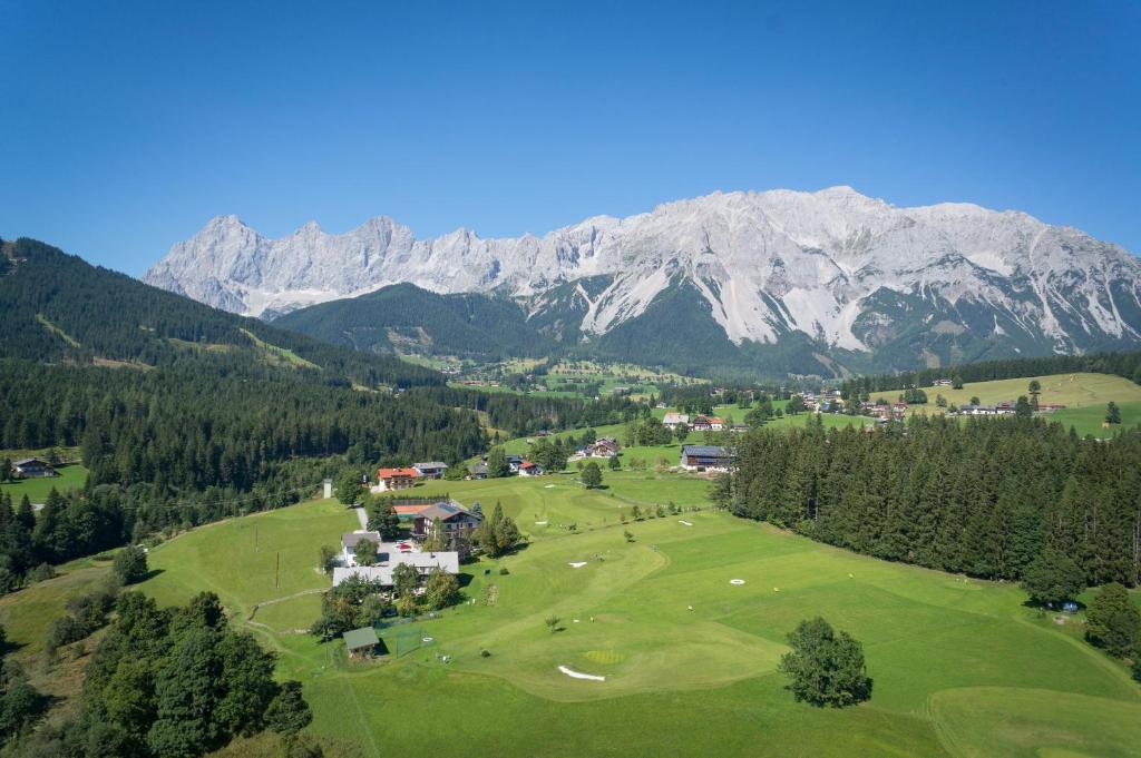 an aerial view of a golf course in the mountains at Kobaldhof in Ramsau am Dachstein