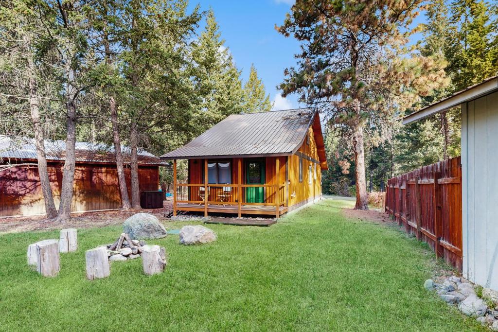 eine Holzhütte in einem Hof neben einem Zaun in der Unterkunft Moose Chalet in Bigfork