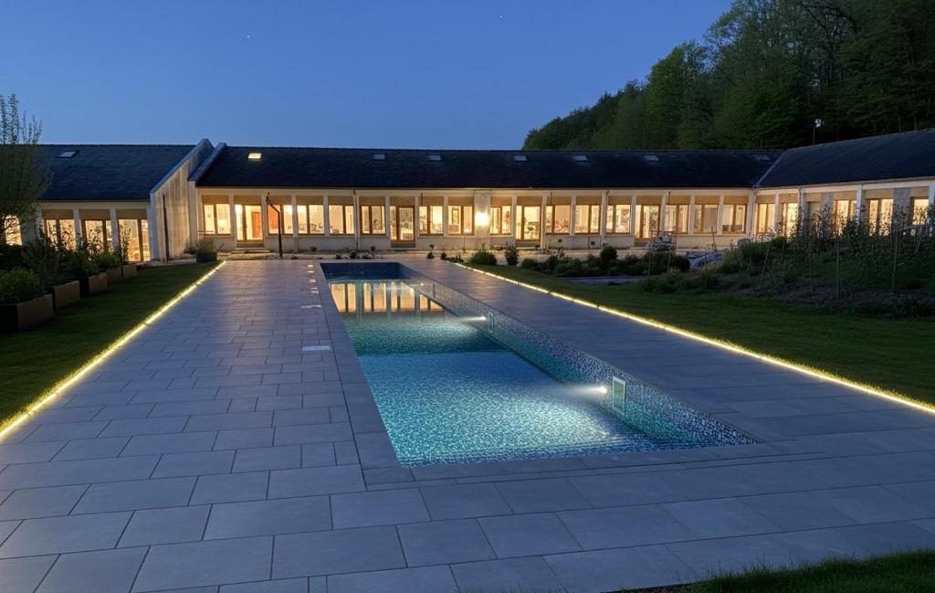 a house with a swimming pool at night with lights at Domaine LAPEDAGNE in Arette