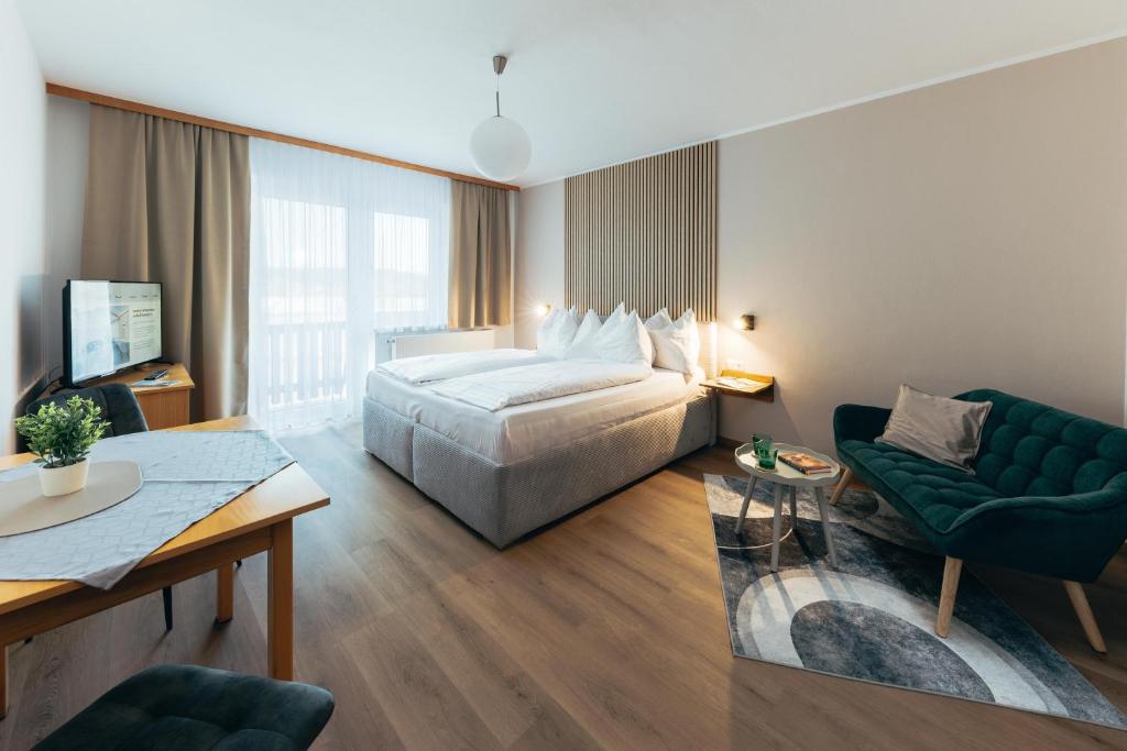 a hotel room with a bed and a couch at B&B Number 1 in Loipersdorf bei Fürstenfeld