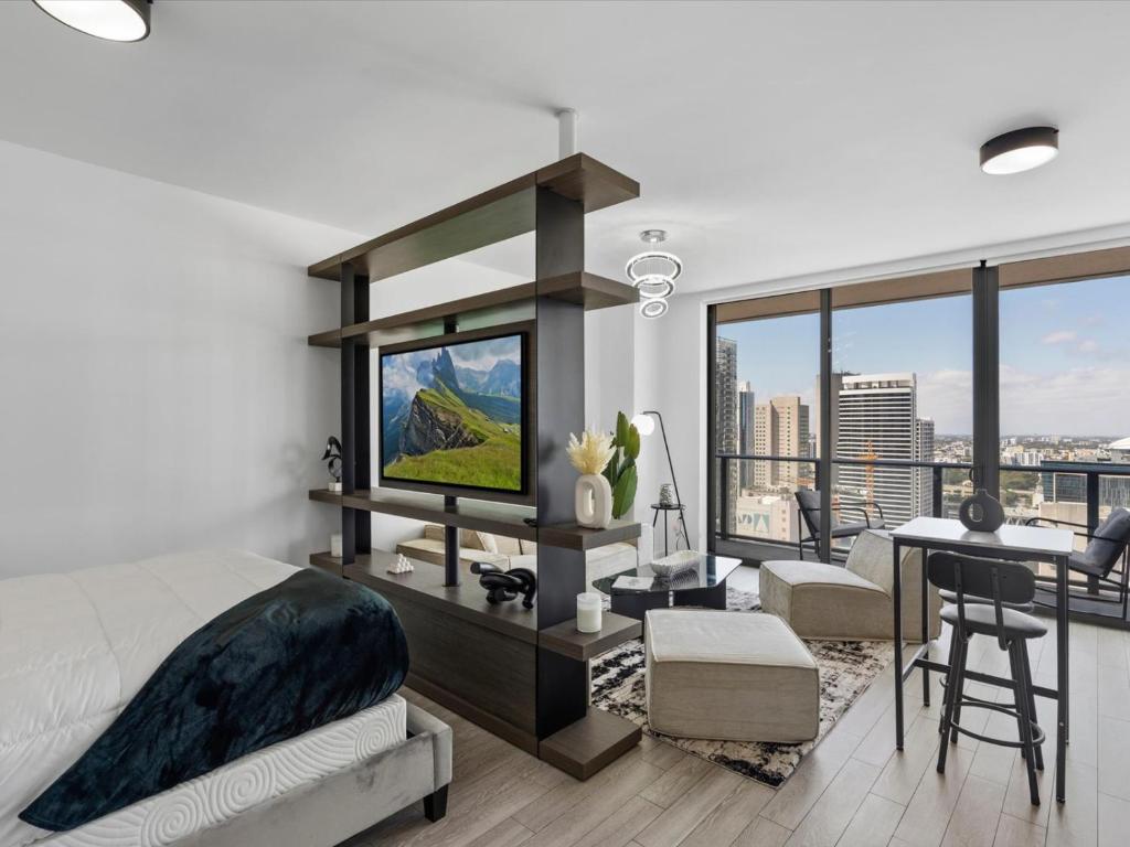 a bedroom with a bed and a desk with a television at 29th Floor Balcony Studio Miami Skyline Views in Miami