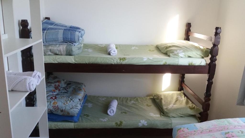 two bunk beds in a room with pillows at Apartamento Central in Penha