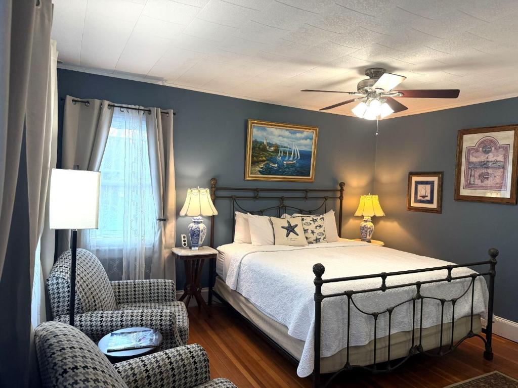 a bedroom with a bed and a chair at Saltair Inn Waterfront B&B in Bar Harbor