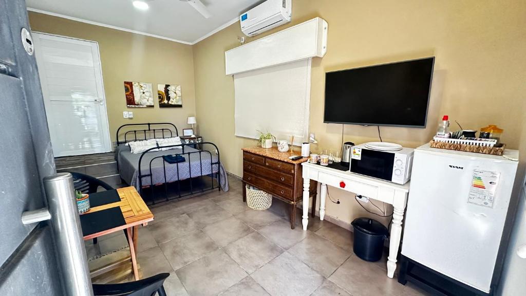 a kitchen with a refrigerator and a tv on the wall at Casa AMBAR in Concordia
