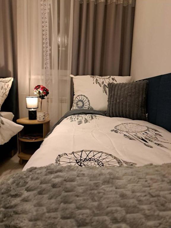 a bedroom with a bed and a table with a lamp at JULIA Apartament- Oświęcim in Oświęcim
