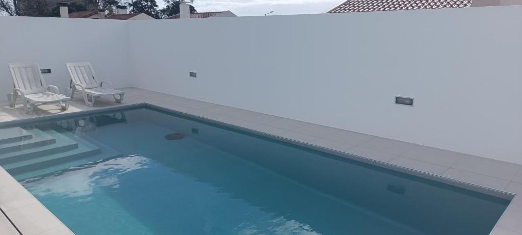 a large swimming pool with two chairs next to it at Brava in Vila Franca do Campo