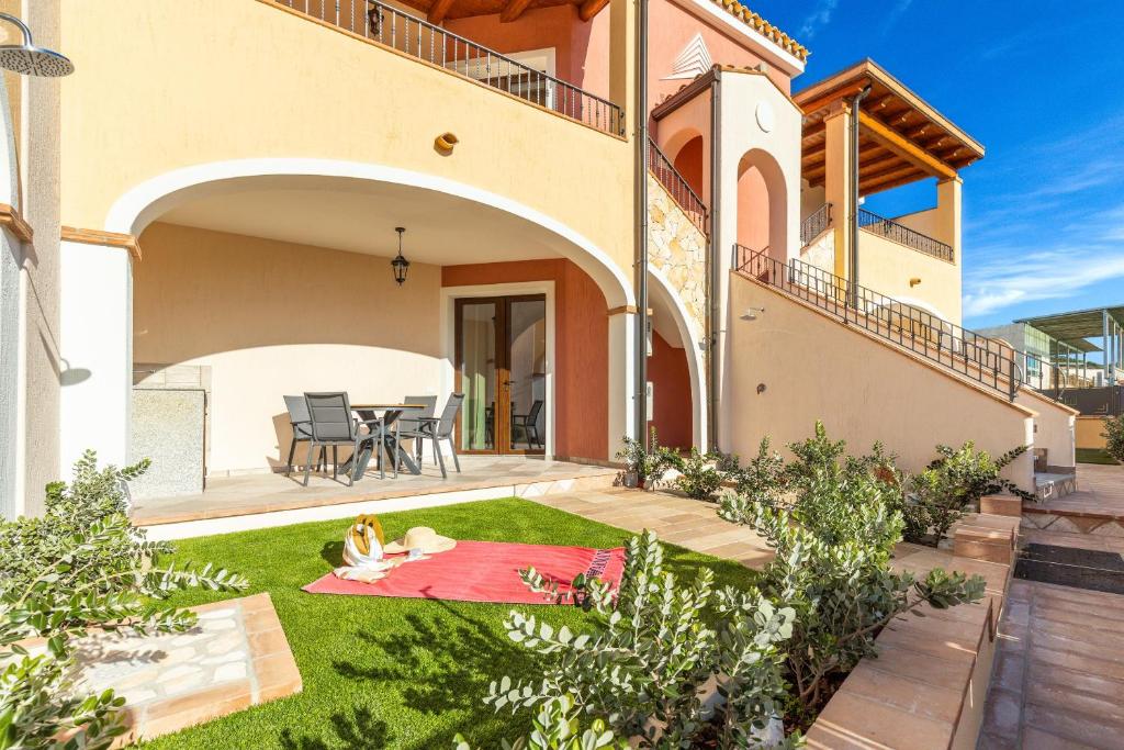 a villa with a garden in front of a house at Agorà Apartments in Villasimius