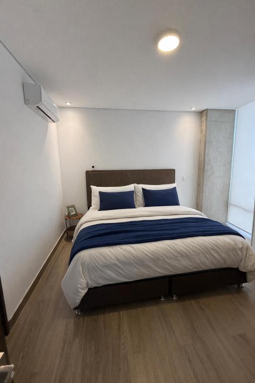 a bedroom with a large bed with blue pillows at Apartment in Torre Empiria in Torreón
