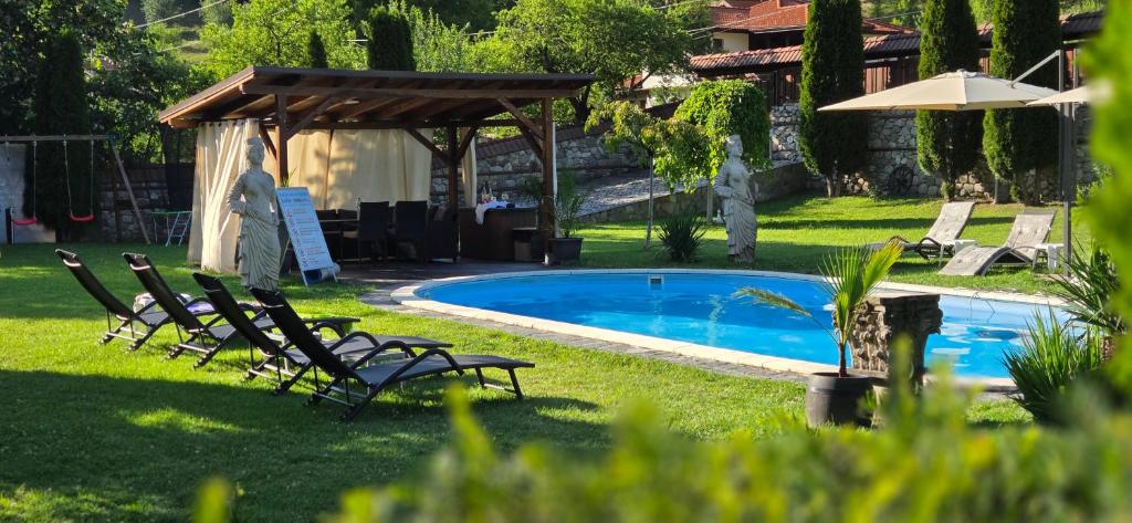 a group of chairs sitting around a swimming pool at Къща за гости Бели Вит in Ribarica
