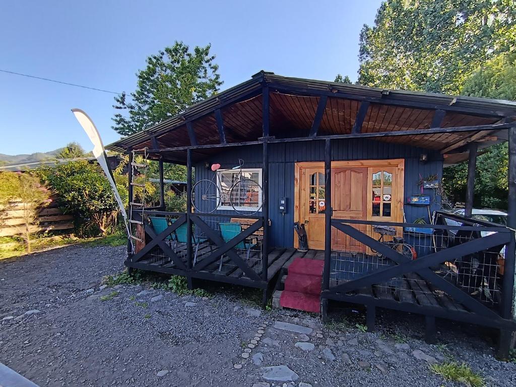 a small house with a surfboard in front of it at Refugio PARQUE NACIONAL ALERCE ANDINO in Puerto Montt