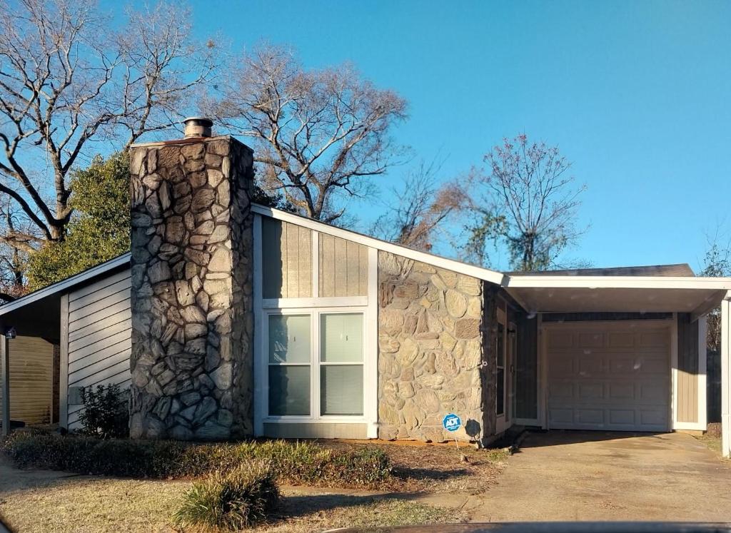 a stone house with a garage and trees at The Elect at Pinewood in Millbrook