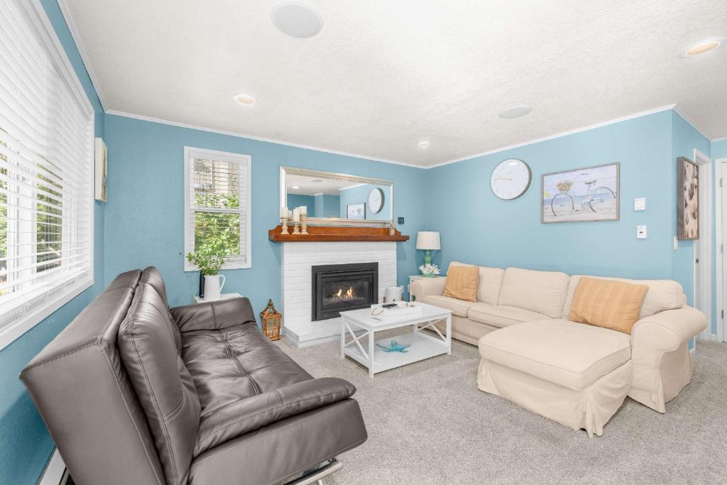 a living room with a couch and a fireplace at Bright Beach Town Bungalow in Gleneden Beach