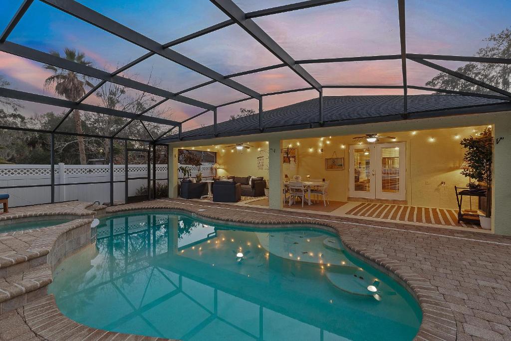 a swimming pool in a house with a glass roof at Sip of Sun in New Smyrna Beach