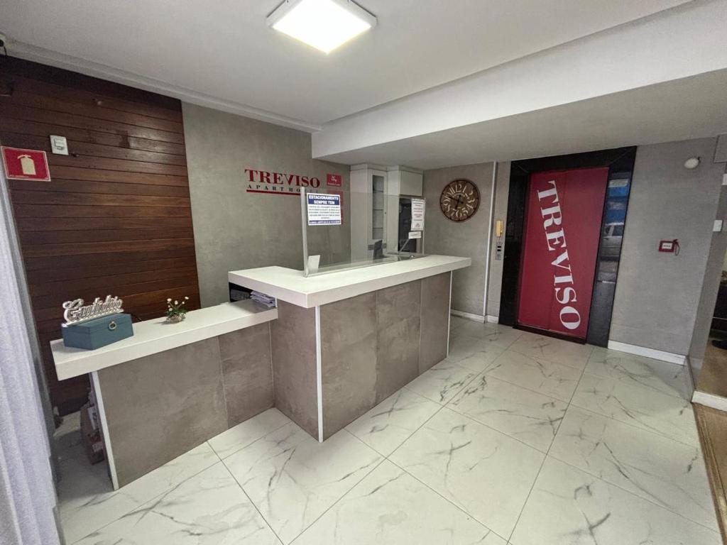 a hotel lobby with two sinks and a sign on the wall at Hotel Treviso suítes in Linhares