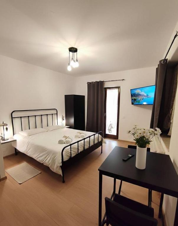 a bedroom with a bed and a table in it at La Dimora di Alma in Clivio