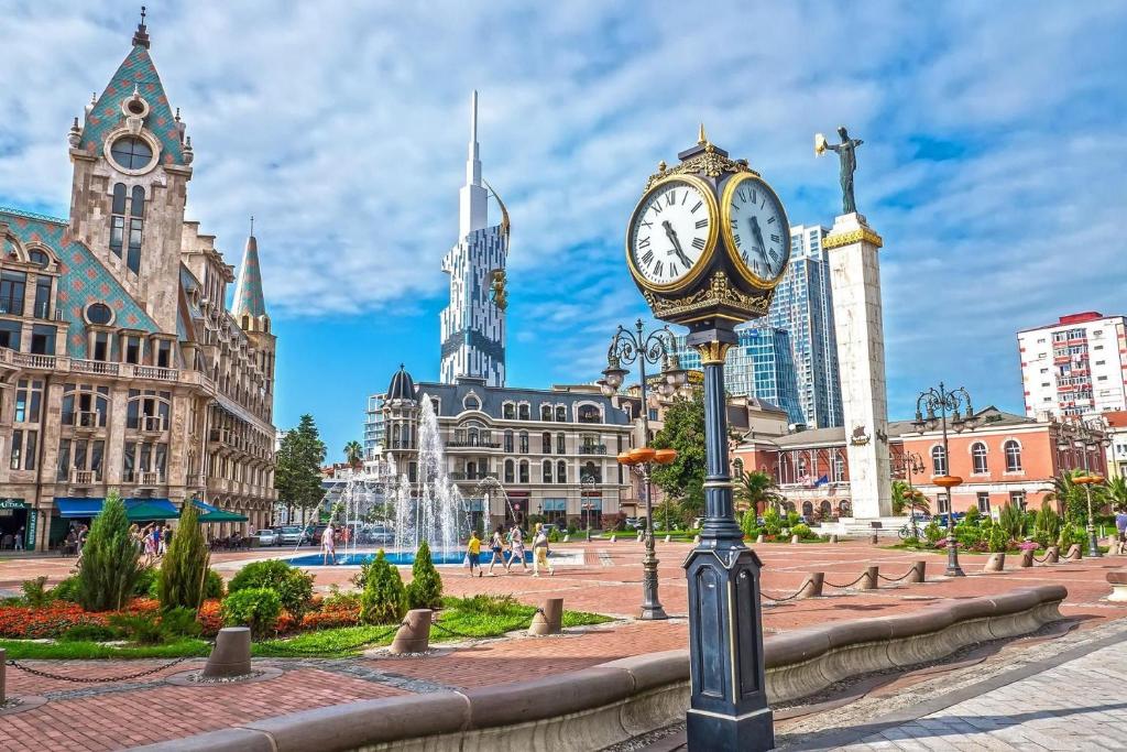 a clock on a pole in the middle of a city at Albatross Luxe Hotel in Batumi