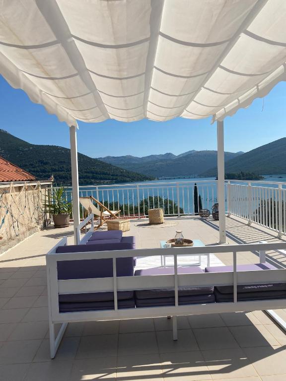 a patio with a white umbrella and a table at Apartment MiriMore in Hodilje