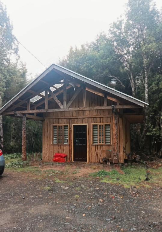 a small wooden house with a gambrel roof at Cabaña monoambiente N 2 in Chaitén