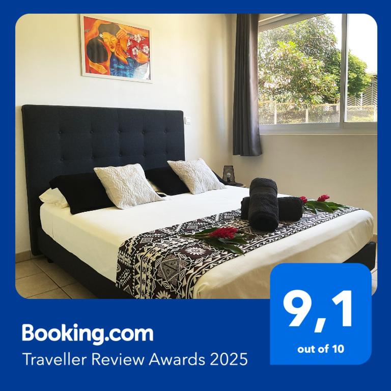 a bedroom with two beds with flowers on them at Prestige Lodging City Center in Papeete
