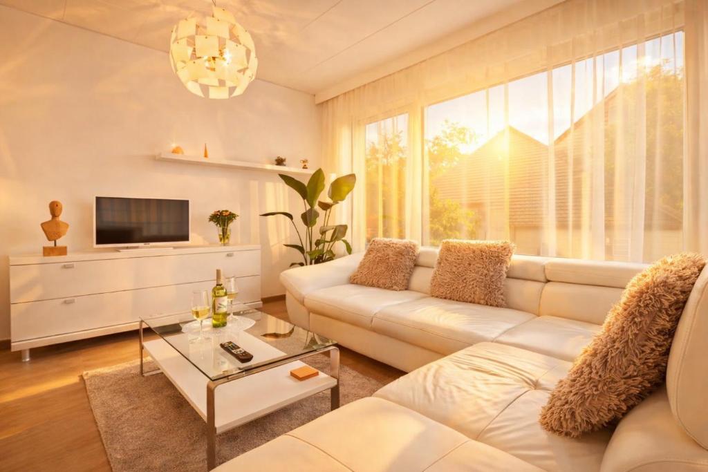 a living room with a white couch and a tv at Deluxe Apartment mit Terrasse Prestige 2 in Friedrichshafen