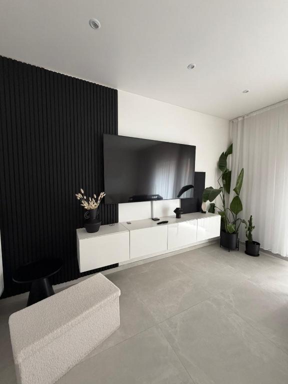 a living room with a couch and a tv at La Priva House in Charleroi