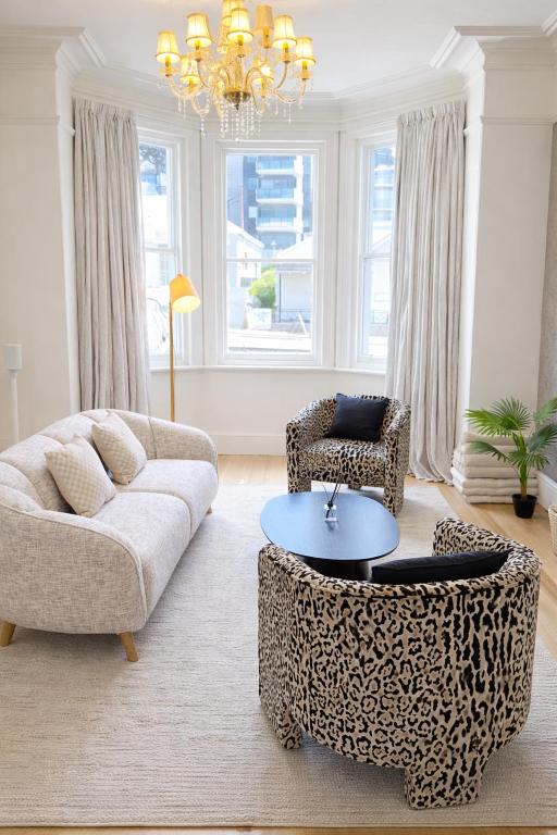 a living room with a couch and chairs and a chandelier at Hobart Retreats - Sanctuary and Haven in Hobart