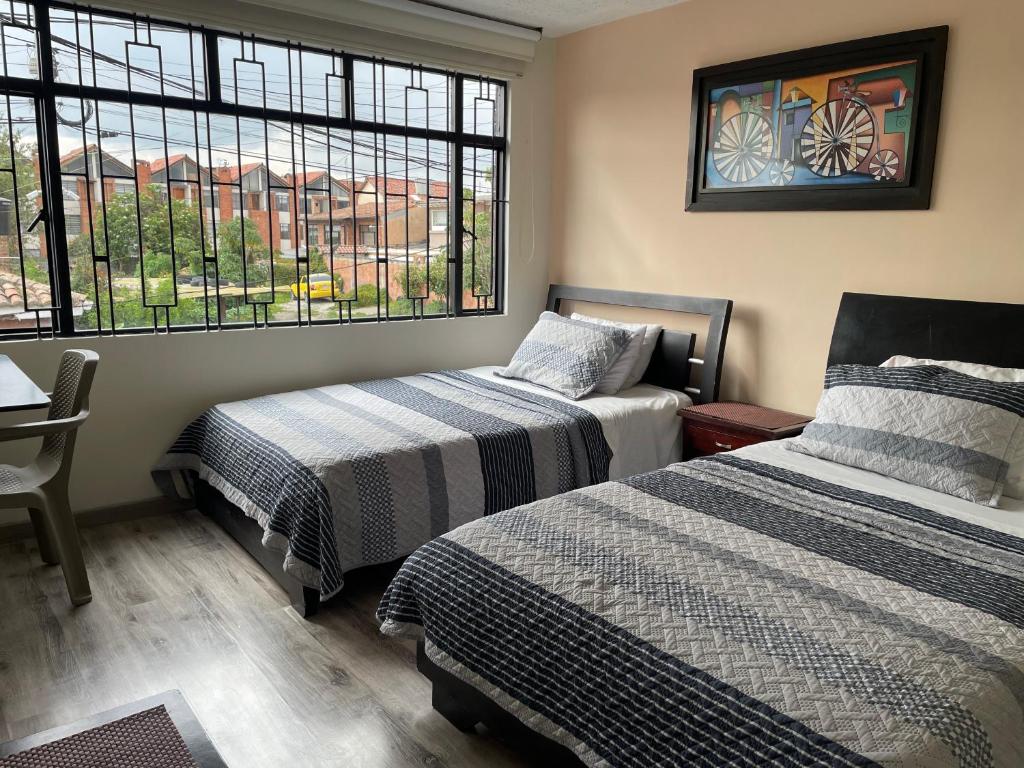 a bedroom with two beds and a window at Casa Bachué Hotel Boutique in Chía