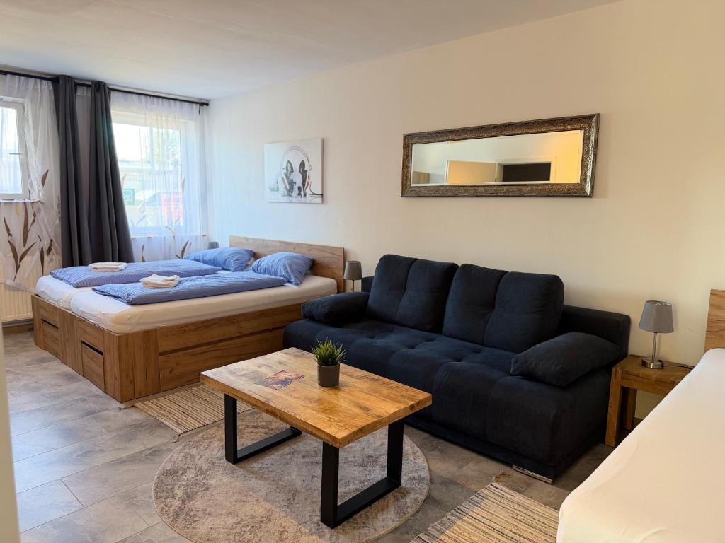 a living room with a couch and a bed at Pension Genat in Wedemark