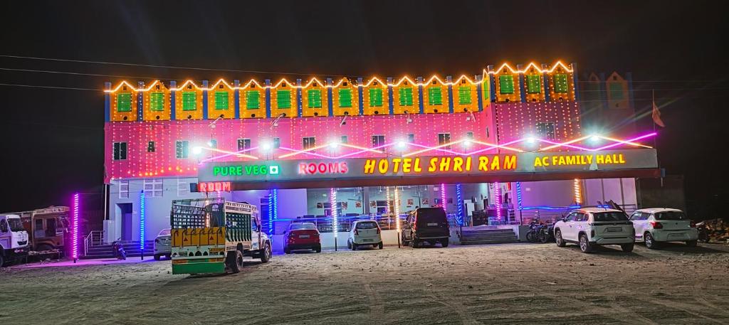 a lit up building with cars parked in front of it at Hotel Shree Ram in Kishangarh