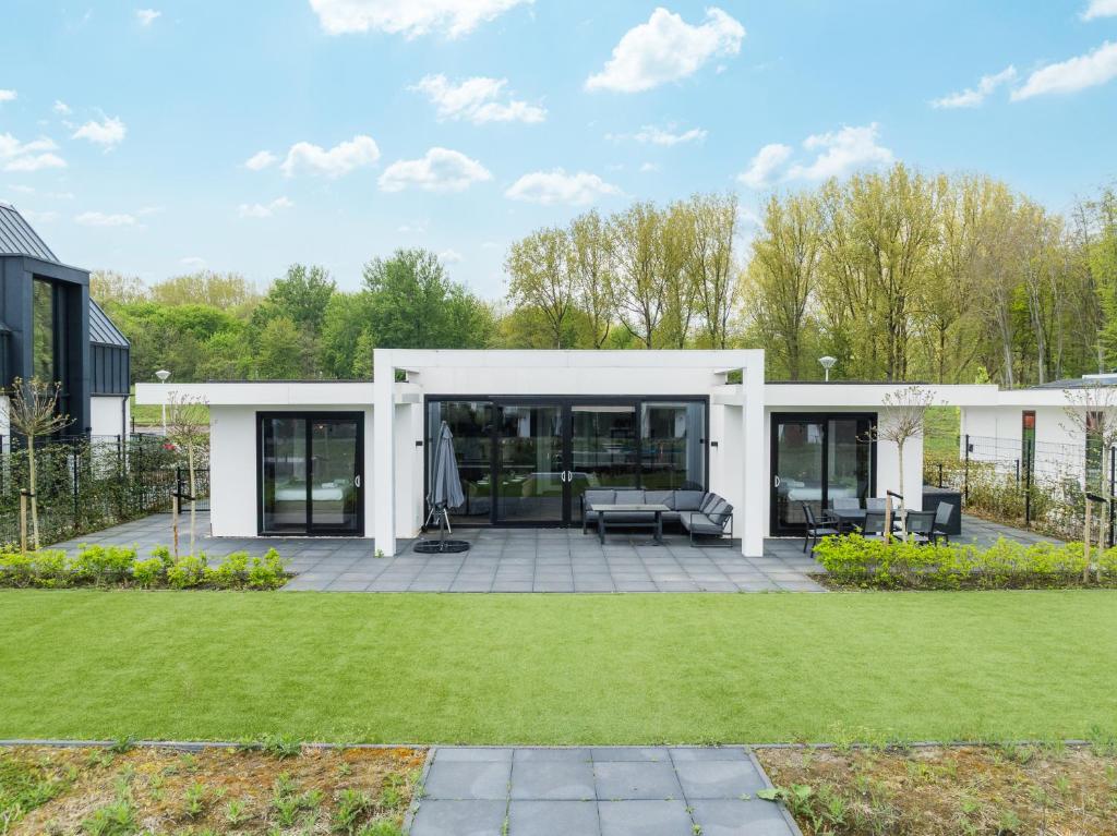 a modern house with a patio and grass at Harderwold Villa - 551 in Zeewolde