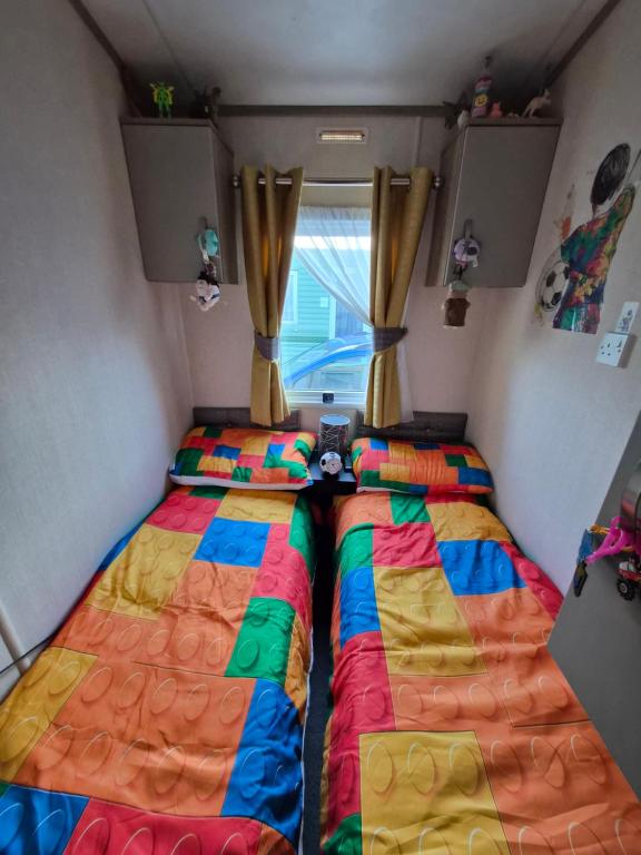 two beds in a small room with a window at Hills residence in Morecambe